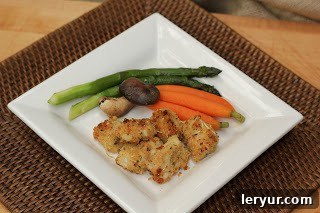 Overhead view of perfectly baked golden chicken nuggets served on a white plate with steamed green beans and carrot sticks, ready to be enjoyed