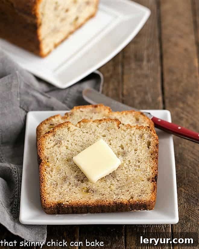 Buttermilk Banana Bread - sweet, tender, and dense banana loaf that's perfect for breakfast, brunch, and snacking! Two perfectly cut slices of Buttermilk Banana Bread artfully presented on a pristine square white plate, accompanied by a melting pat of butter.