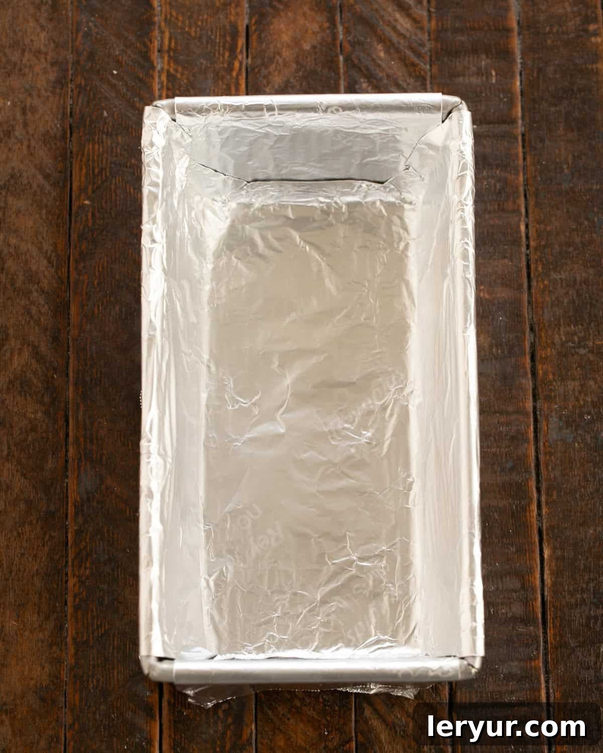 Velvety Buttermilk Banana Bread 3 Loaf pan being prepared by greasing and lining with parchment paper.