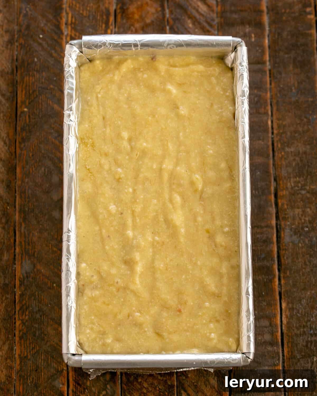 Velvety Buttermilk Banana Bread 7 Banana bread batter being scraped into the prepared loaf pan.
