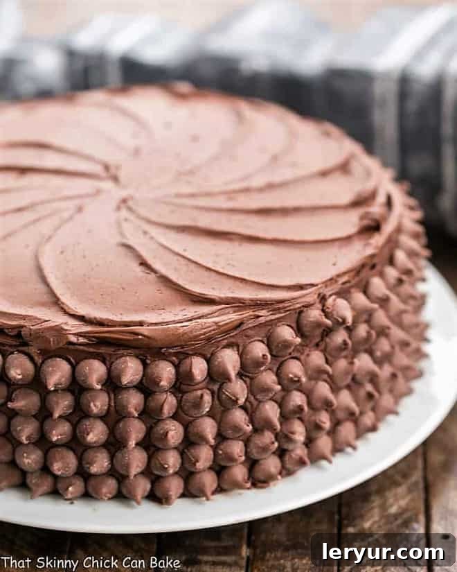 A stunning chocolate layer cake, expertly frosted and adorned, revealing a rich chocolate cheesecake filling.