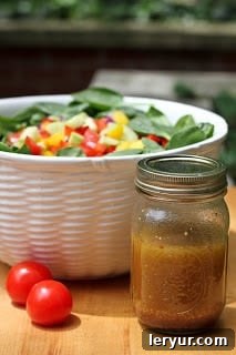 Gazpacho Spinach Salad - a refreshing vegetable salad with a piquant red wine vinaigrette Gazpacho spinach salad in a white serving bowl with a mason jar of salad dressing.