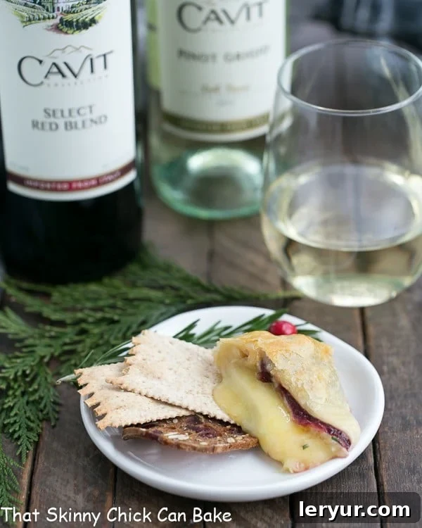 A slice of Cranberry Brie en Croute served on a small appetizer plate with crisp crackers.