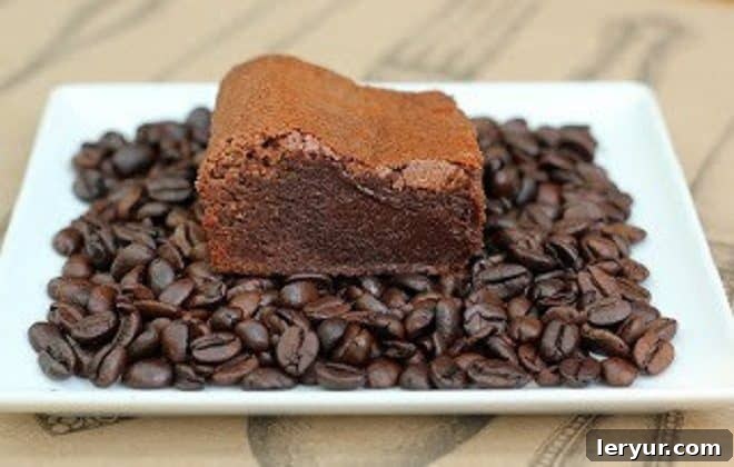 A nostalgic shot of Kahlua Brownies on a white plate, nestled among coffee beans, highlighting their classic appeal.