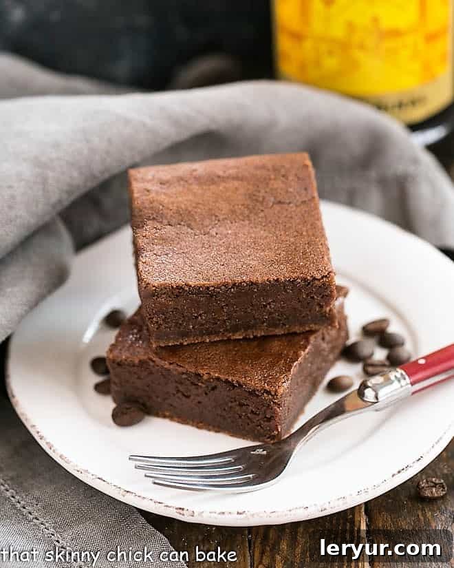 Fudgy Kahlua brownies on a white plate with a striking red handled fork, ready to be enjoyed