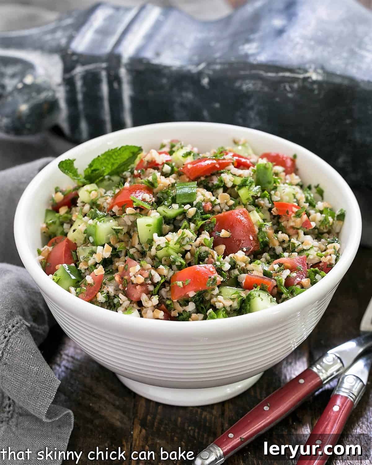 Mastering Classic Tabbouleh 2 A taboouli recipe in a white serving bowl with 2 forks.