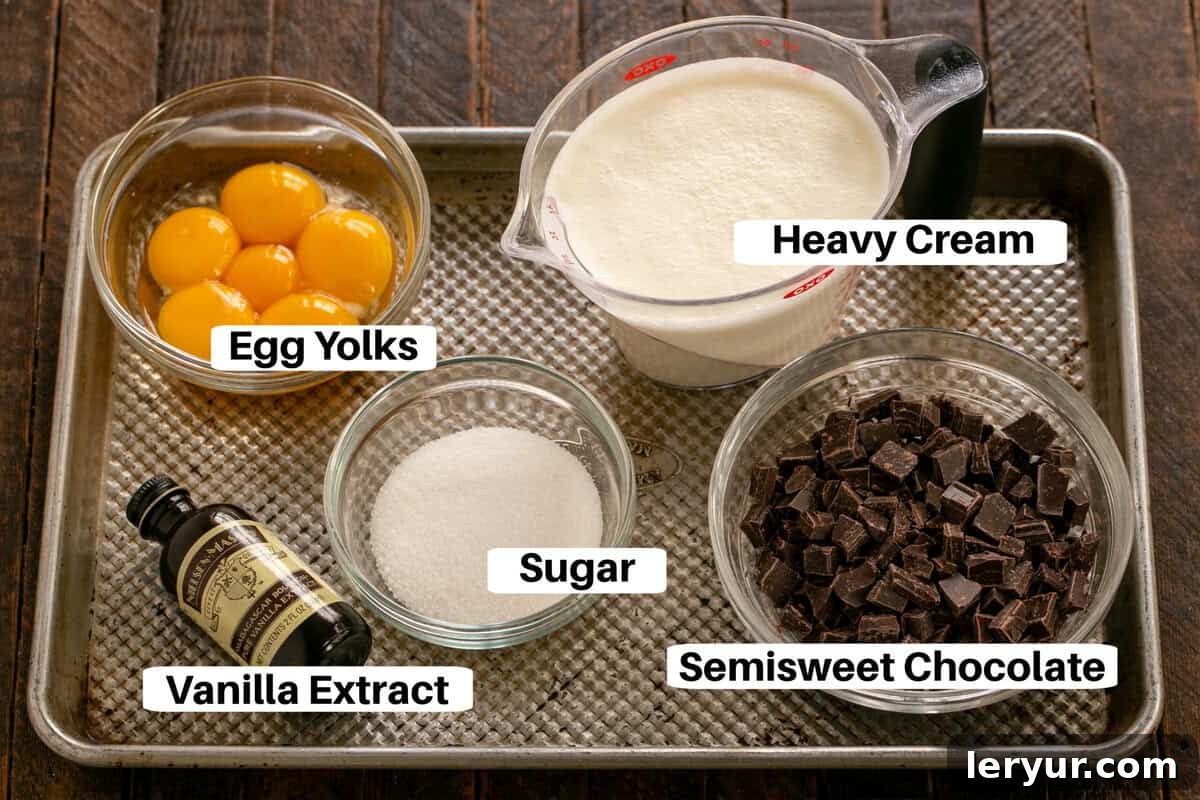 Ingredients for Chocolate Pots de Creme, including heavy cream, chocolate, sugar, egg yolks, and vanilla extract, laid out on a metal sheet pan with labels.