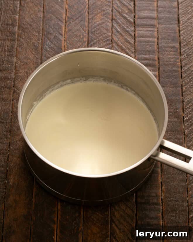 Heavy cream simmering in a saucepan.
