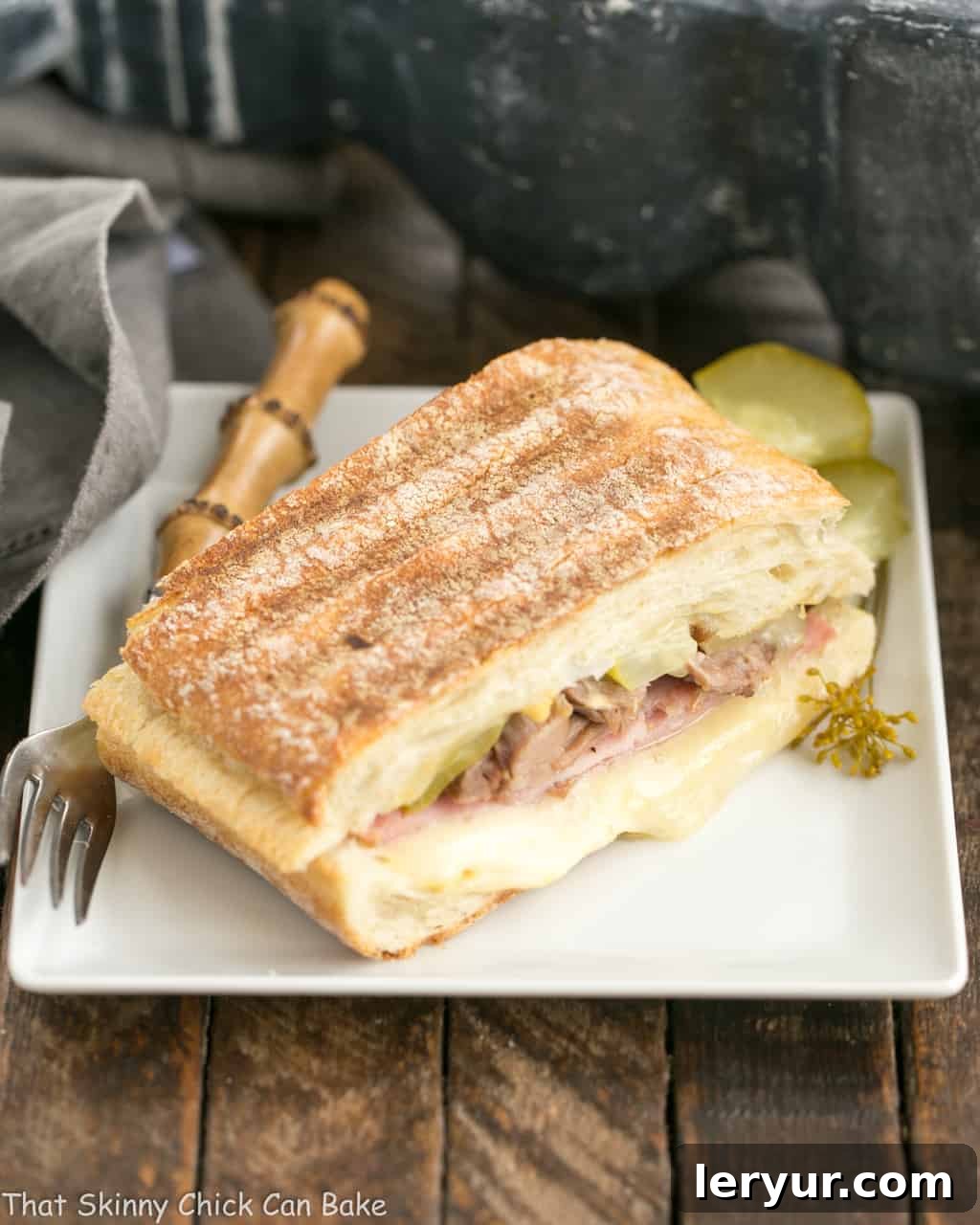Ciabatta Cubano Sandwich on a square white plate, showing golden grill marks and melted cheese.