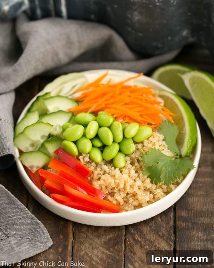 Quinoa Salad in a white bowl, showcasing fresh vegetables and a vibrant dressing.