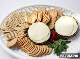 Best Pesto Dip Recipe - a delicious appetizer recipe with an Italian flair Overhead view of layered Italian dip on a tray with crackers