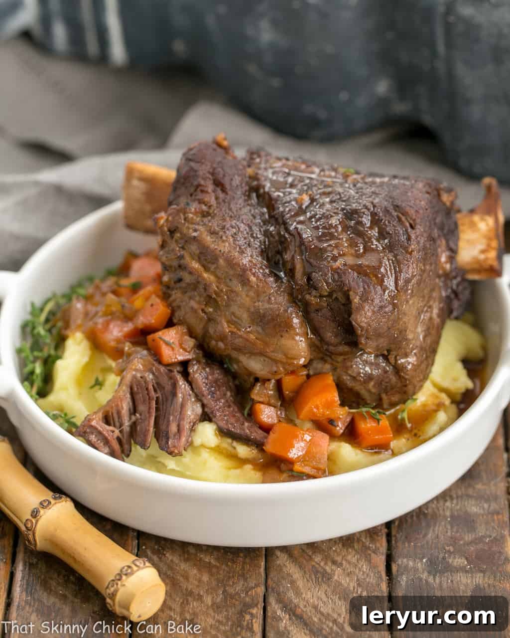 Instant Pot Beef Short Ribs - A quick cooking time make these short ribs a perfect dinner any day of the week Instant Pot Beef Short Ribs on a round white plate over mashed potatoes and carrots, garnished with fresh herbs.