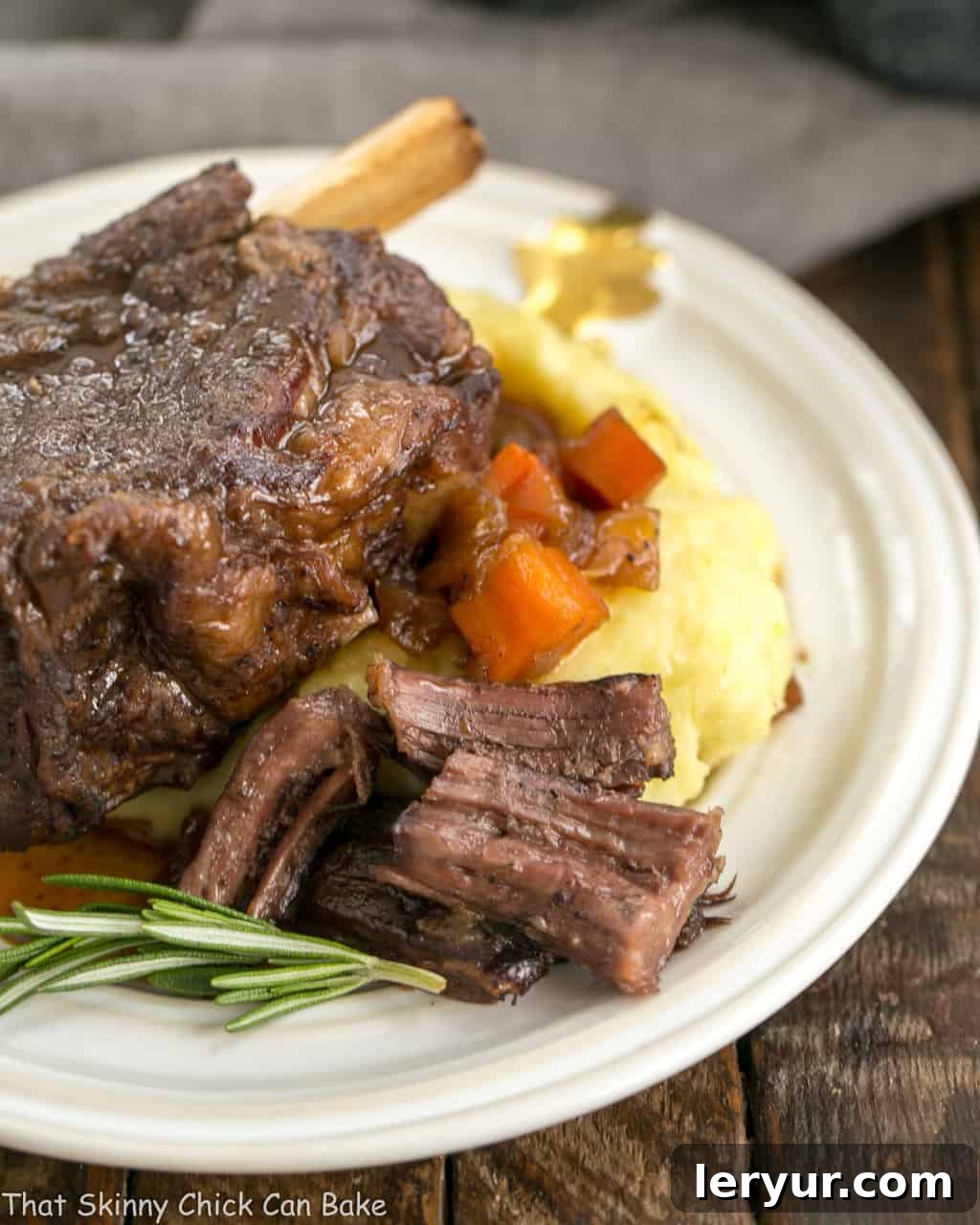 Instant Pot Beef Short Ribs - A quick cooking time make these short ribs a perfect dinner any day of the week Instant Pot Beef Short Ribs on a white plate with a side of creamy mashed potatoes and a sprinkle of fresh herbs.