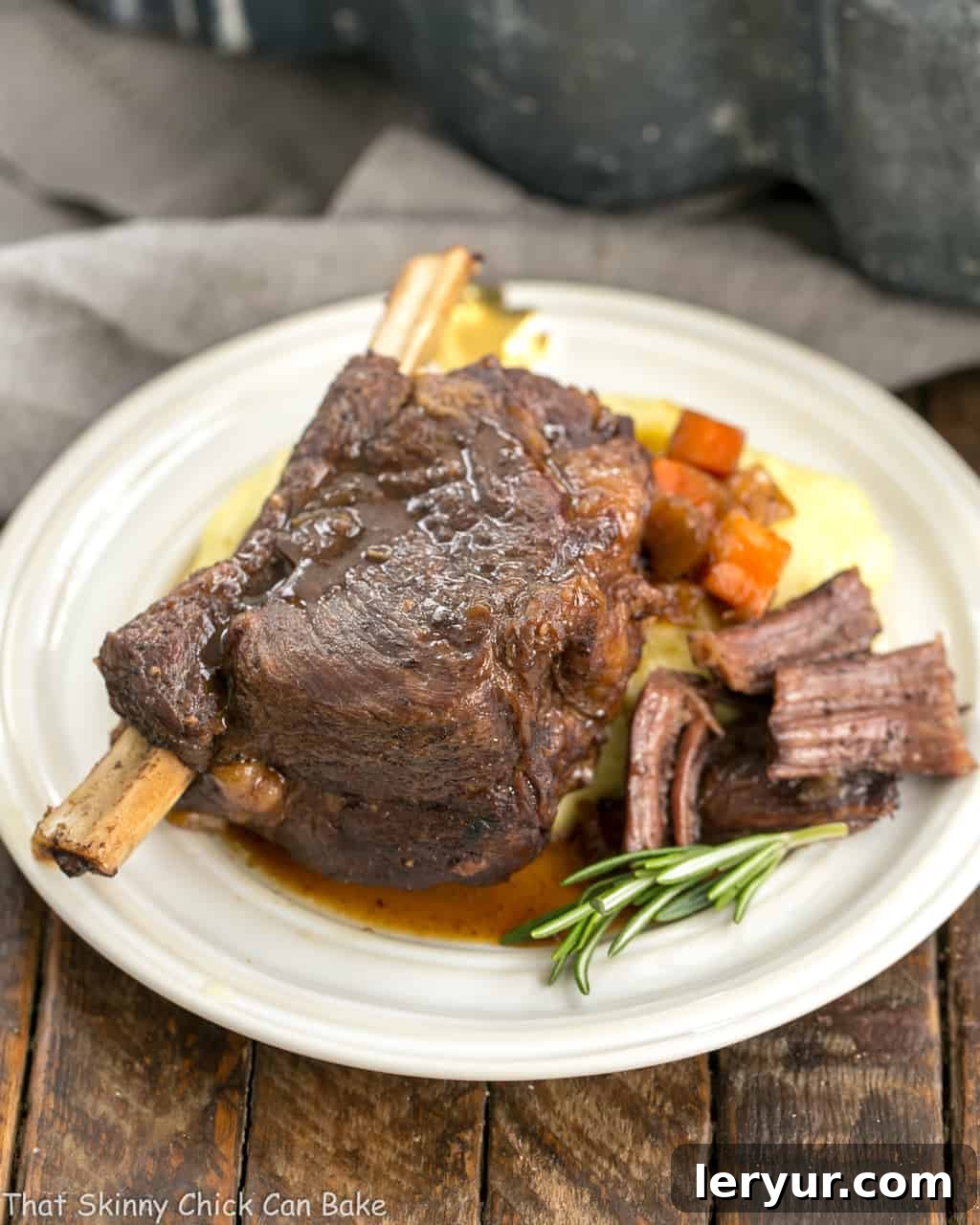 Instant Pot Beef Short Ribs - A quick cooking time make these short ribs a perfect dinner any day of the week Instant Pot Beef Short Ribs on a round white plate garnished with fresh rosemary sprigs.