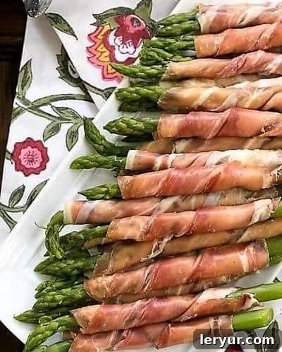 Prosciutto Wrapped Asparagus Step 4: Finished prosciutto wrapped asparagus bundles are neatly arranged on a tray, ready to be chilled and served.