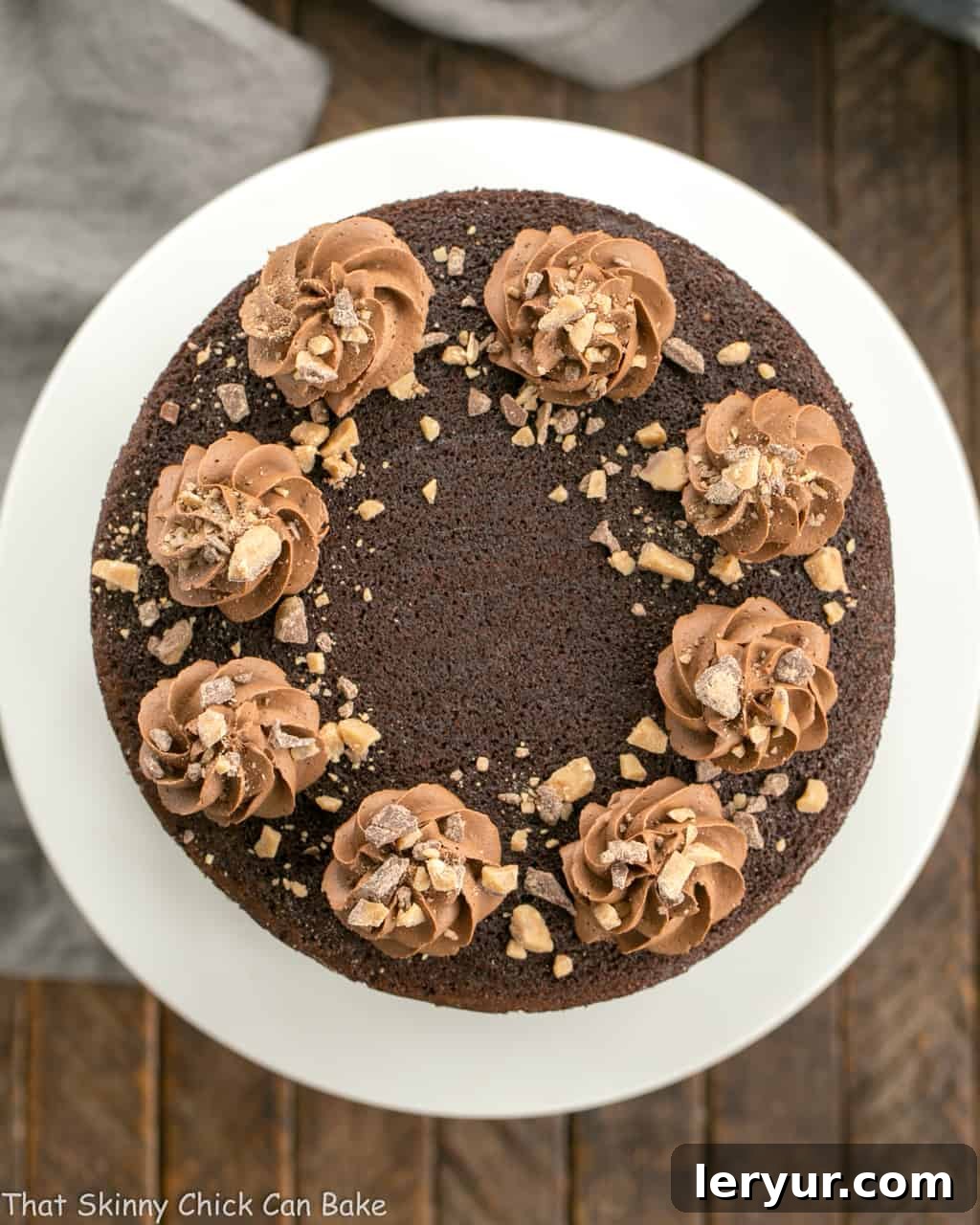 An inviting overhead view of the Triple Layer Chocolate Toffee Cake, beautifully decorated with swirls of frosting and sprinkled with toffee bits, ready to be sliced and enjoyed.