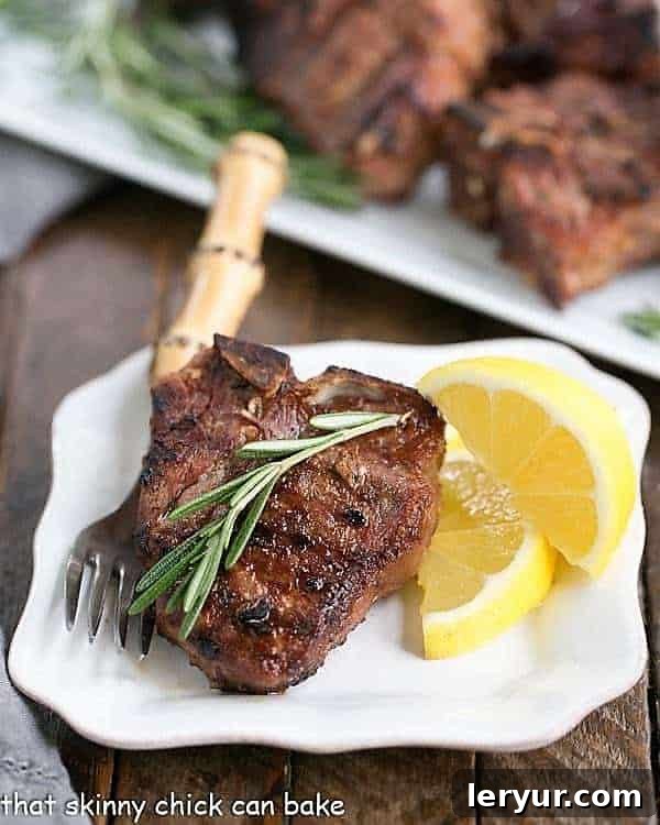 Grilled Lamb Chops with Mustard, Rosemary and Garlic - The most fabulous way to enjoy lamb!! Grilled Lamb Chops with Mustard, Rosemary and Garlic on a small white plate with a sprig of rosemary and lemon wedges