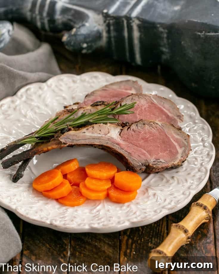 overhead view of frenched lamb chops on a white plate with a bamboo handled fork