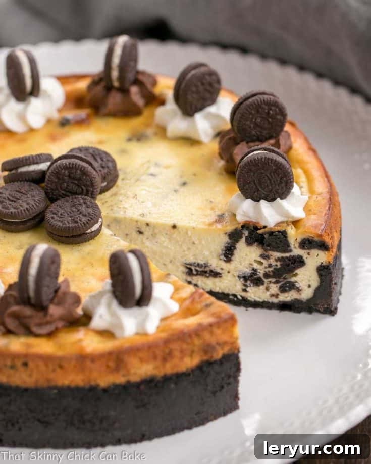 Oreo Cheesecake with Oreo Cookie Crust with a slice removed on a white serving plate, showcasing its rich texture and irresistible appeal.