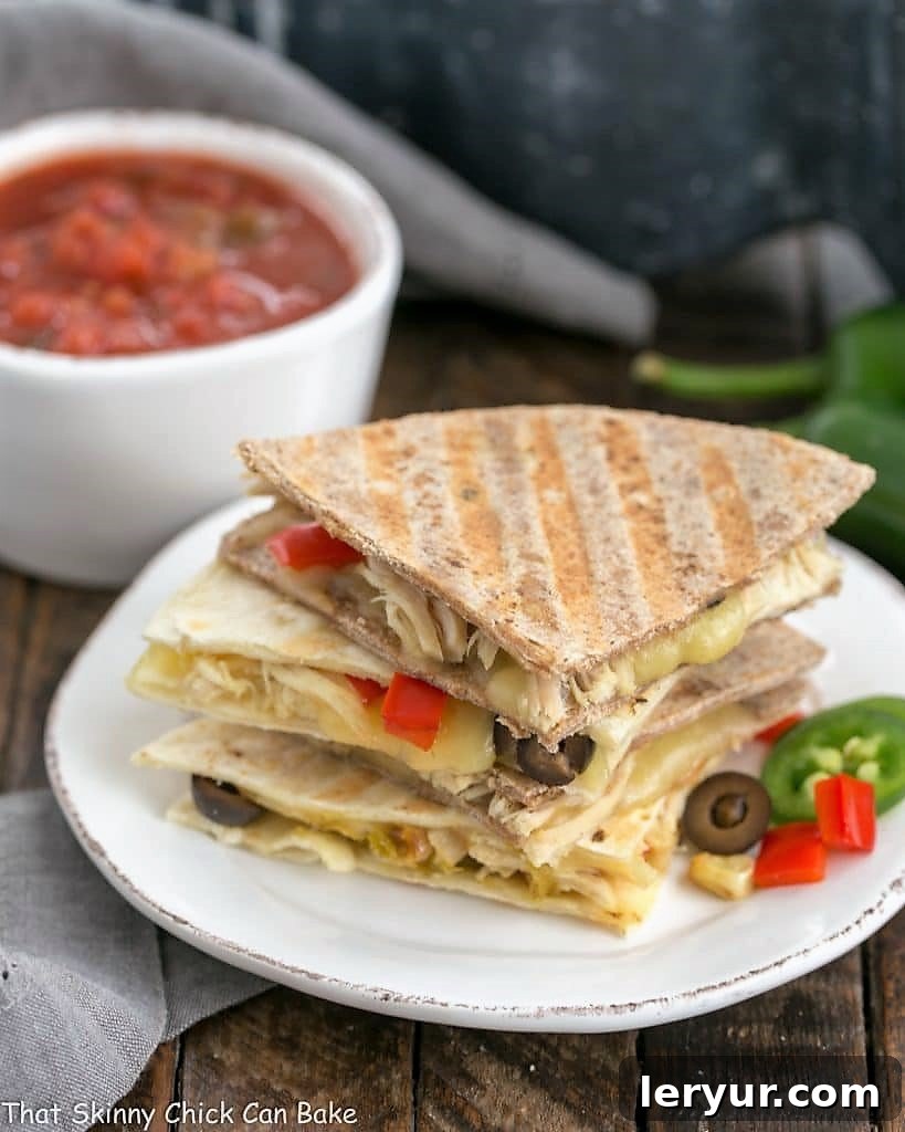 Cheesy Chipotle Chicken Quesadillas with red bell peppers, onions, corn, and Monterey jack cheese Cheesy Chipotle Chicken Quesadillas stacked on a round white plate