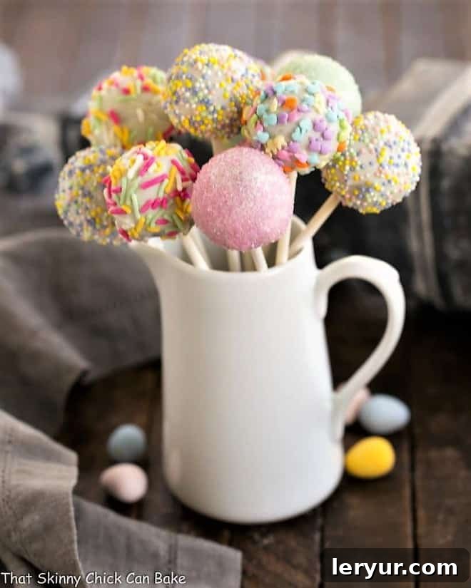 Delightful Easter Cake Pops - An Easy No-Bake Recipe for Any Celebration Festive Easter Cake Pops beautifully arranged in a ceramic pitcher, adorned with colorful sprinkles.