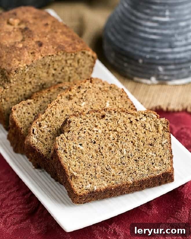 Easy Irish Brown Bread - A hearty, healthy quick bread recipe Easy Irish Brown Bread loaf and slices on a white tray, showcasing its rustic texture and inviting color.