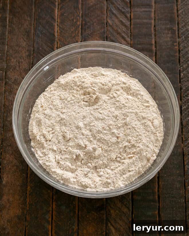 Effortless Traditional Irish Soda Bread 4 Cold butter being rubbed into the dry ingredients mixture with fingers, resembling cornmeal.