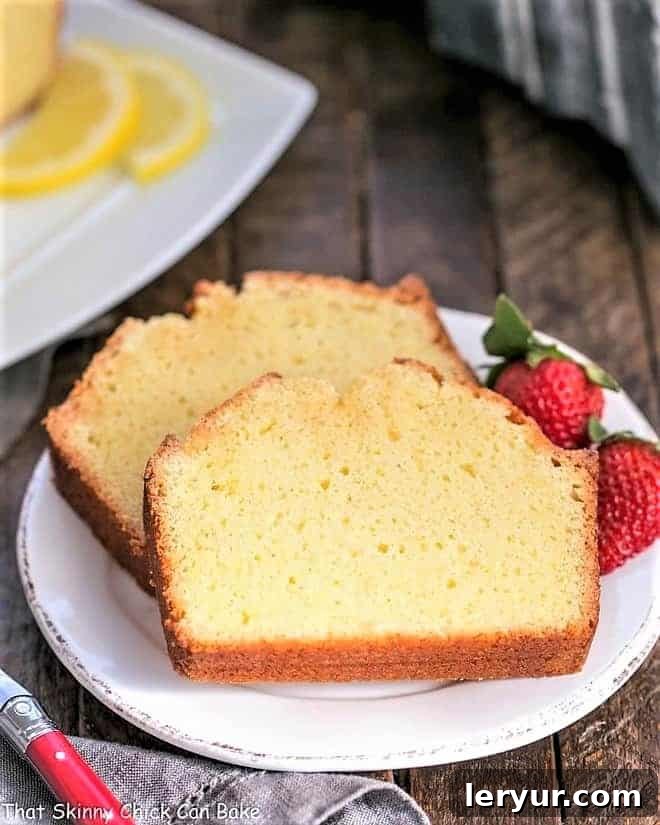 Glazed Lemon Cake Recipe - served with whipped cream and berries for a delightful dessert Glazed Lemon Pound Cake slices garnished with berries. A perfect dessert for any occasion.