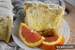 Orange Pull-Apart Coffee Cake - a unique, delicious bread recipe flavored with orange! A perfectly portioned slice of orange coffee cake on a small white plate, accompanied by fresh orange segments, ready to be enjoyed.