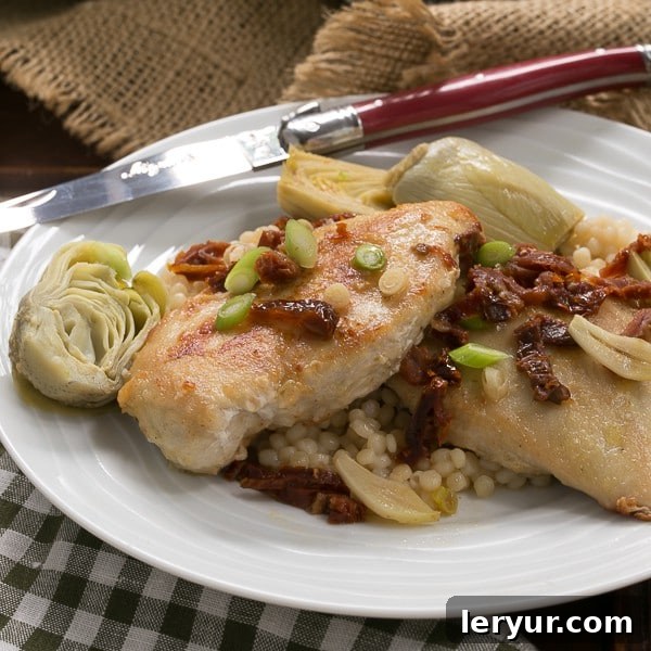 Tuscan Chicken with Sun-Dried Tomatoes and Artichokes 2 Chicken with artichokes and sundried tomatoes on a white plate