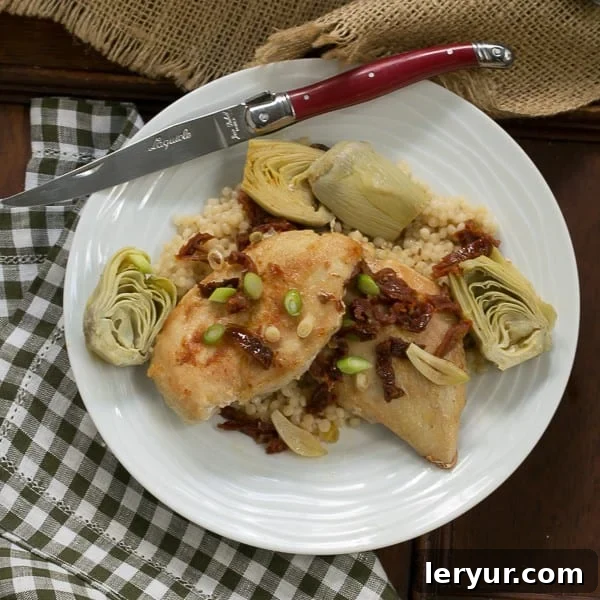 Tuscan Chicken with Sun-Dried Tomatoes and Artichokes 3 Overhead view of Chicken with artichokes and sundried tomatoes on a white plate