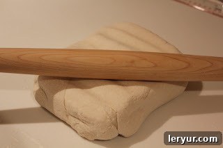 Prosciutto Gruyère Pinwheels made with homemade puff pastry A sheet of homemade puff pastry being carefully rolled out on a floured surface, the first step in creating the pinwheel appetizers.