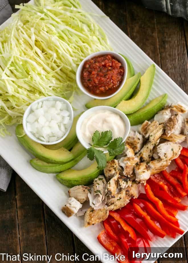 An inviting overhead view of a beautifully arranged fish taco platter, showcasing perfectly cooked, flaky white fish, vibrant shredded cabbage, creamy avocado slices, and zesty lime wedges, all artfully displayed on a pristine white ceramic platter.
