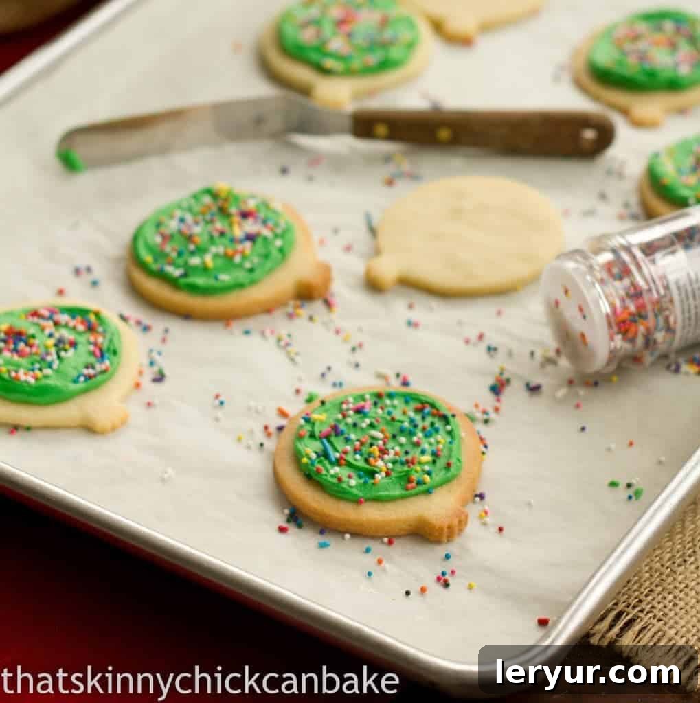 Freshly baked cream cheese sugar cookies on a baking sheet, ready for frosting.