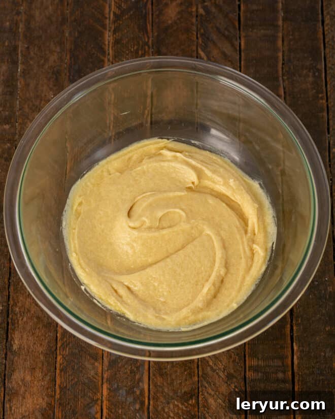 Step 1: Mixing melted butter with both sugars, then adding vanilla and egg.