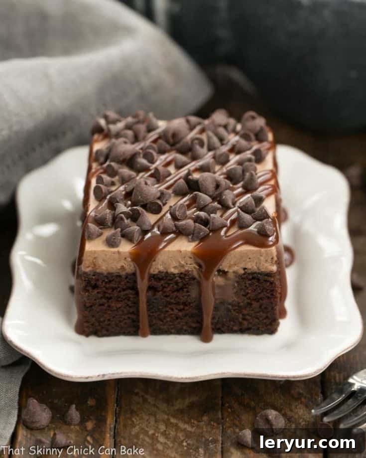 A stunning Chocolate Kahlua Poke Cake ready to be served, topped with generous chocolate whipped cream and garnishes.