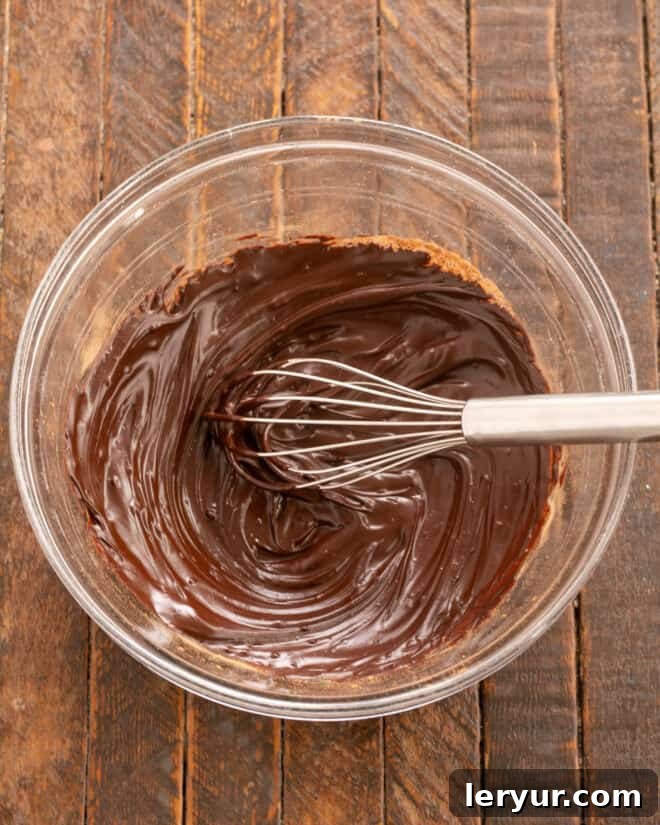 Velvet Night Snack Cakes 10 Cocoa powder being mixed into melted butter for the Black Magic Cake frosting, creating a rich chocolate paste.