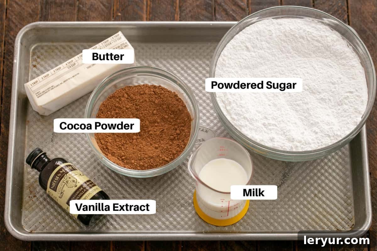 Velvet Night Snack Cakes 3 The essential ingredients for the Black Magic Cake frosting, including cocoa powder, butter, powdered sugar, milk, and vanilla, neatly displayed on a sheet pan with labels.