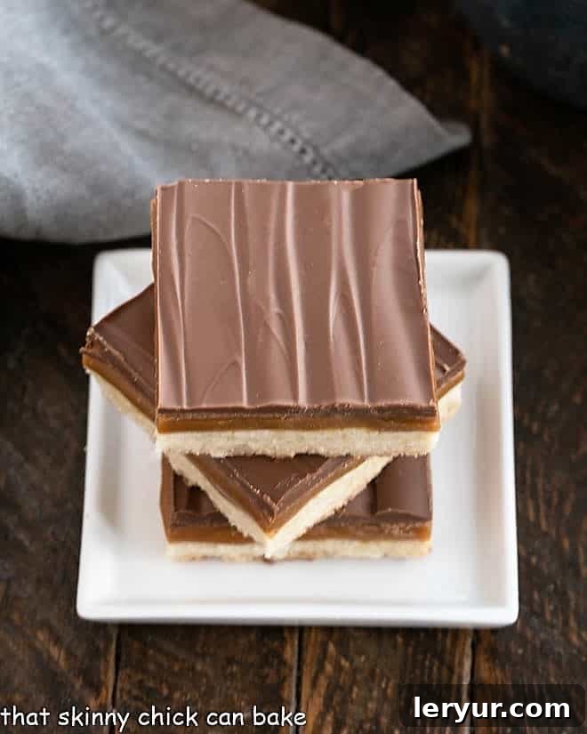 Overhead view of 3 homemade Twix bars stacked on a small square white plate