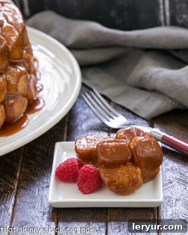 Bubble bread on a square white plate with 2 plump raspberries, showcasing the smaller, quartered roll version for an elegant presentation.