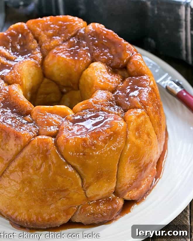 Easy Monkey Bread on a white serving plate, showing the original recipe using full-sized roll dough, coated in rich caramel.