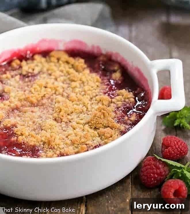 Fresh Raspberry Crisp in a round white casserole dish, baked to golden perfection with a bubbly filling.