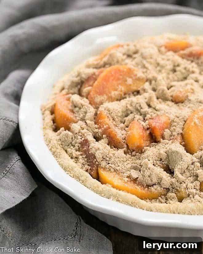 Easy Peach Crumb Pie, unbaked and ready for the oven, displaying the generous peach filling and crumb topping.