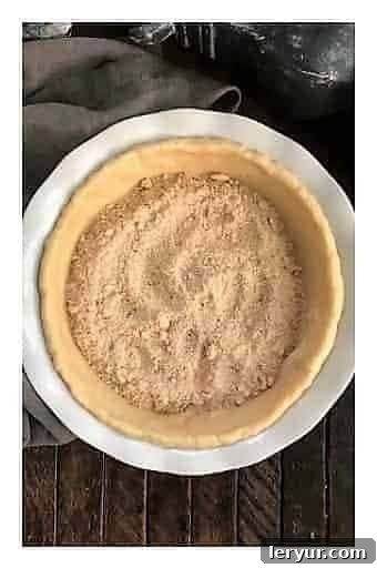 Peach Crumb Pie Step 2: Adding a layer of the crumb mixture to the bottom of the crust.