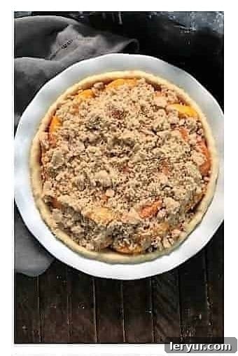 Peach Crumb Pie Step 4: Topping the peaches with the remaining crumble mixture.