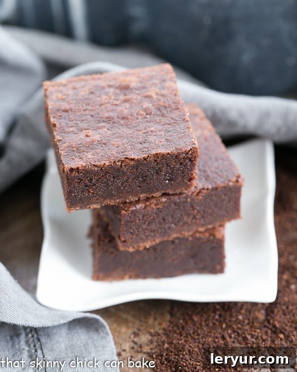 Multiple Palm Beach Mocha Brownies stacked elegantly on a small white plate, ready to be served.