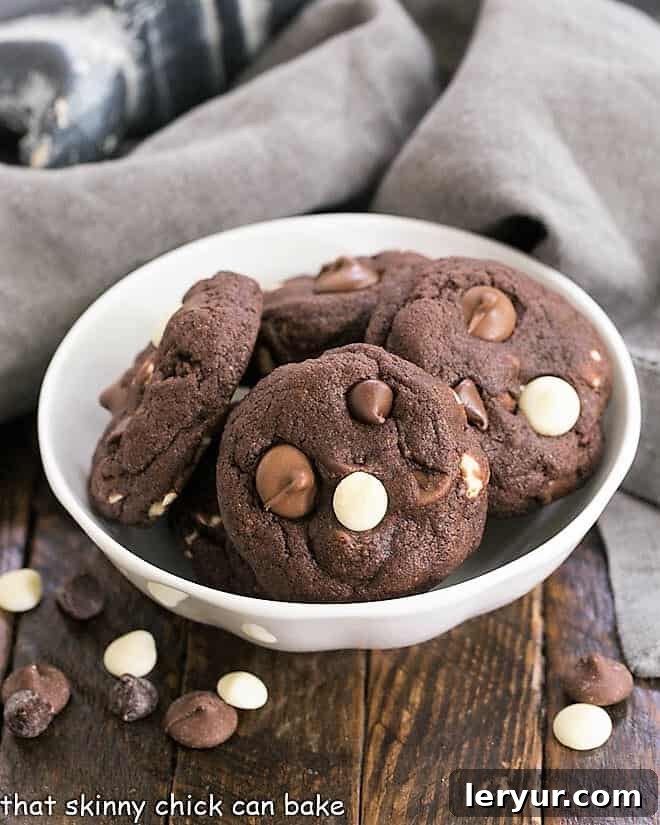 Quadruple Chocolate Cookies in a white bowl surrounded by chocolate chips