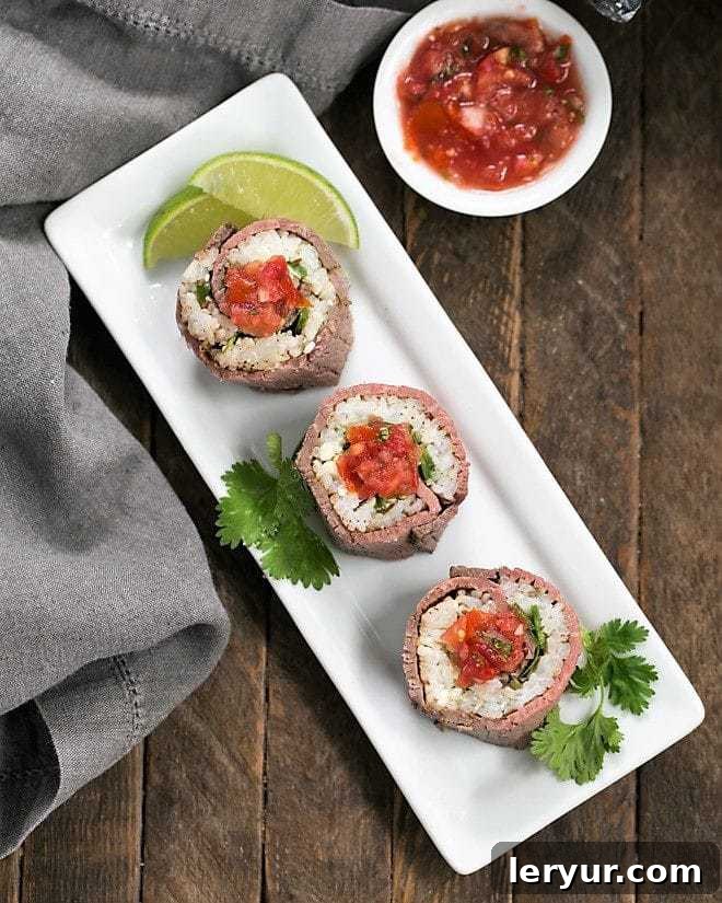 Exquisitely presented Beef Texan Rolls on a pristine white rectangular tray, generously topped with a vibrant salsa, highlighting their fresh appeal.