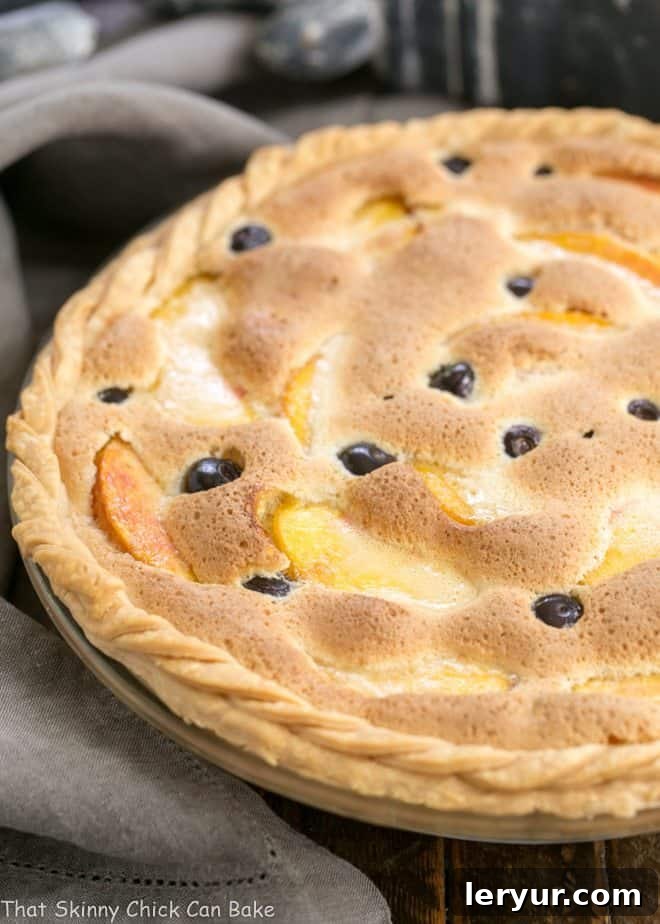 Blueberry Peach Custard Pie - A one crust peach pie speckled with blueberries Peach Blueberry Custard Pie in a glass pie dish with a braided crust.
