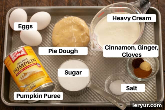 The Secret to Sublime Pumpkin Pie 2 Classic Pumpkin Pie Ingredients meticulously laid out on a metal sheet pan, ready for preparation.